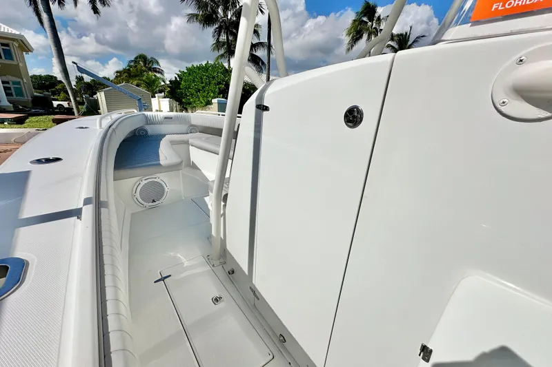 Slide: The Image of 2006 Jupiter 31FS boat interior with seating, speaker, and storage, under a sunny sky. - 36