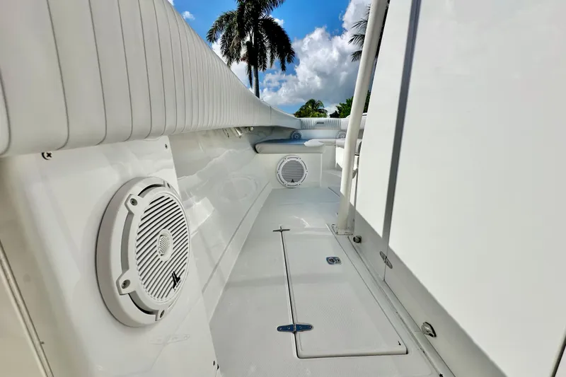 Slide: The Image of 2006 Jupiter 31FS boat interior with speakers, palm trees, and blue sky background. - 38