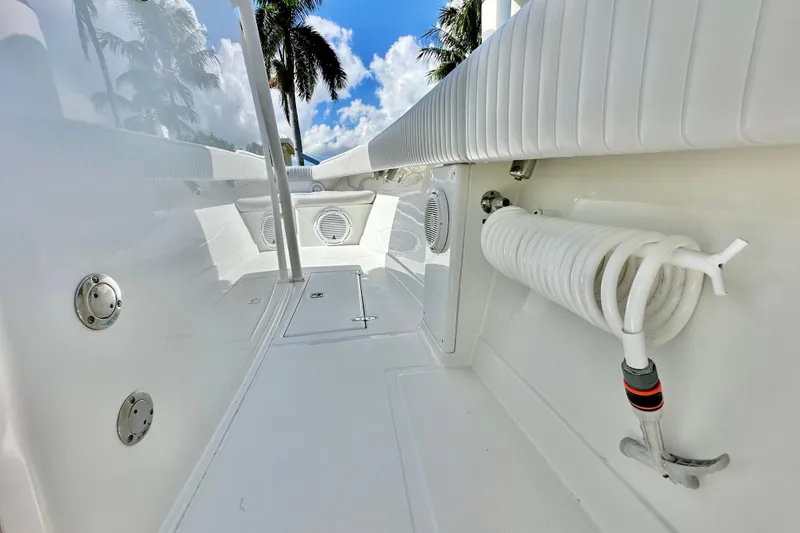 Slide: The Image of 2006 Jupiter 31FS boat interior with coiled hose, white seating, and clear sky background. - 42