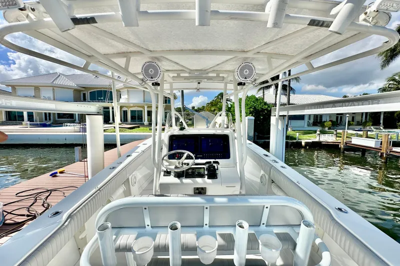 Slide: The Image of 2006 Jupiter 31FS boat interior with steering console, docked by waterfront homes. - 45