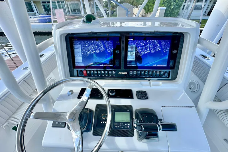 Slide: The Image of Helm of 2006 Jupiter 31FS boat with dual navigation screens and steering wheel. - 49