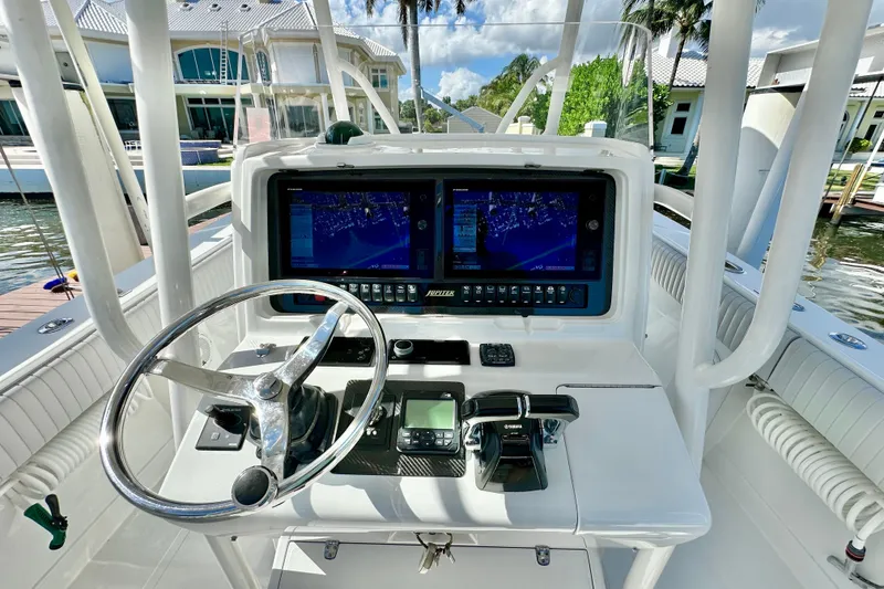 Slide: The Image of Steering console of a 2006 Jupiter 31FS boat with navigation screens and controls. - 50