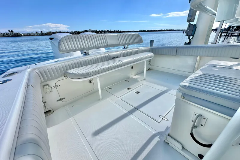 Slide: The Image of 2006 Jupiter 31FS boat interior with white seating and open deck, docked by the water. - 54