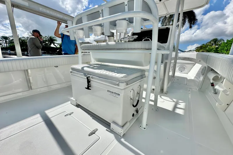 Slide: The Image of 2006 Jupiter 31FS boat interior with seating and storage, under a sunny sky. - 56