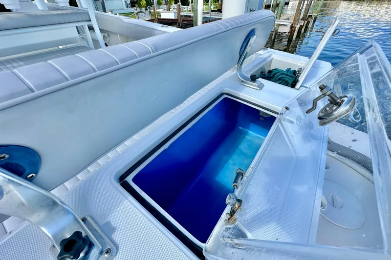 Slide: The Image of 2006 Jupiter 31FS boat with open storage compartments and seating, dockside view. - 63