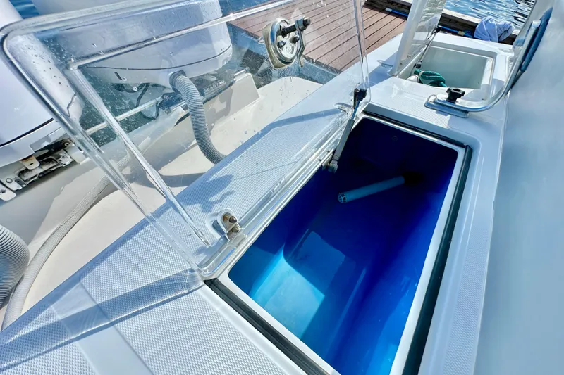 Slide: The Image of Open storage compartment on a 2006 Jupiter 31FS boat, with clear lid and blue interior. - 64