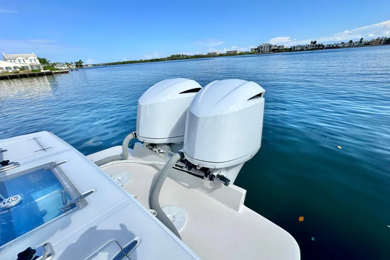 Slide: The Image of 2006 Jupiter 31FS boat with dual outboard motors on a calm waterway. - 69