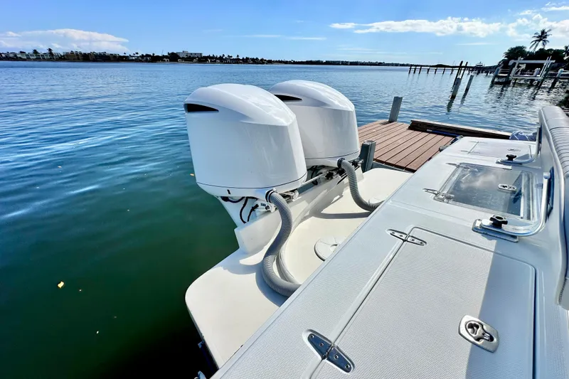 Slide: The Image of 2006 Jupiter 31FS boat with dual outboard motors docked by the water. - 71