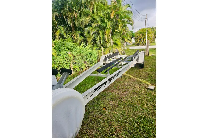 Slide: The Image of Boat trailer for 2006 Jupiter 31FS on grass, surrounded by lush greenery. - 72