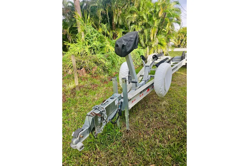 Slide: The Image of Trailer for 2006 Jupiter 31FS boat, parked on grass with lush greenery background. - 73