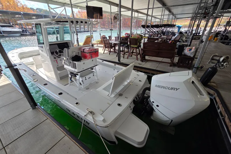 Slide: The Image of 2026 Blackfin 262 HB boat docked with Mercury engine, surrounded by marina setting. - 12