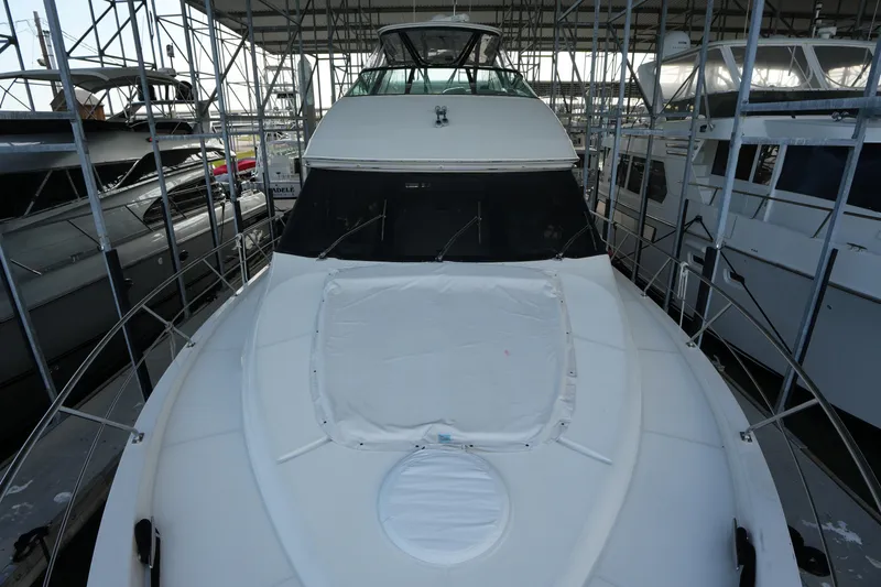 Slide: The Image of 2004 Carver 560 Voyager yacht docked in a marina, surrounded by scaffolding. - 8