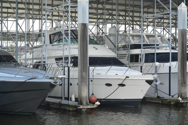 The Image of 2004 Carver 560 Voyager yacht docked in a marina under a metal canopy. - 0