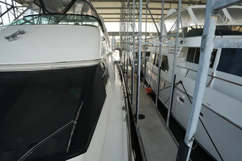 Slide: The Image of 2004 Carver 560 Voyager yacht docked in a marina, surrounded by metal scaffolding. - 12