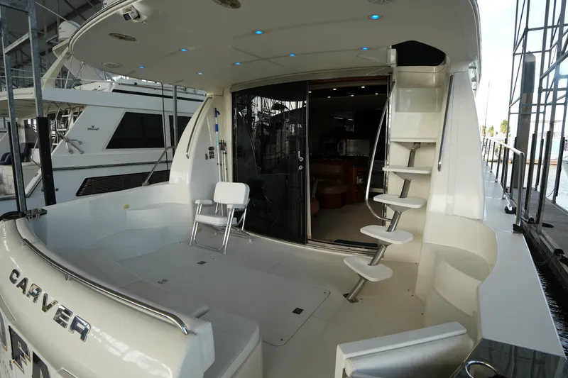 Slide: The Image of 2004 Carver 560 Voyager yacht deck with modern seating and spiral staircase. - 13