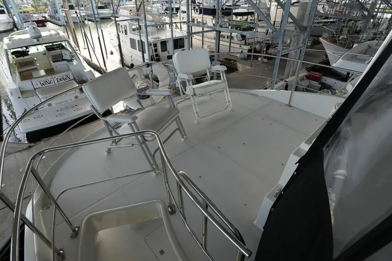 Slide: The Image of 2004 Carver 560 Voyager yacht deck with chairs in marina setting. - 21