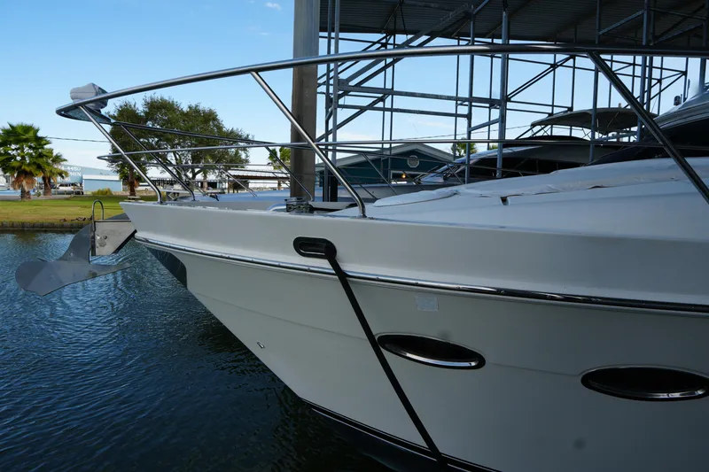 Slide: The Image of 2004 Carver 560 Voyager yacht docked, showcasing sleek design and polished metal railings. - 6