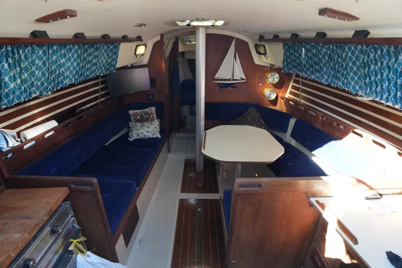 Slide: The Image of Interior of a 1984 O'Day 30 sailboat with blue seating and nautical decor. - 10