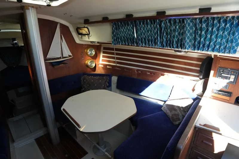 Slide: The Image of Interior of a 1984 O'Day 30 sailboat with blue seating and nautical decor. - 11