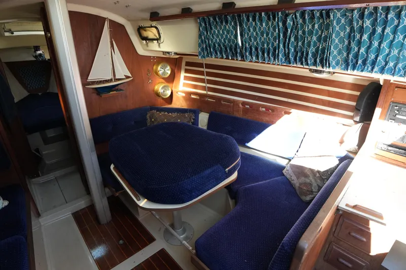 Slide: The Image of Interior of a 1984 O'Day 30 sailboat with blue seating and nautical decor. - 12