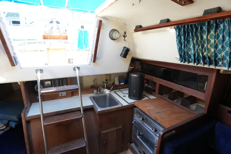 Slide: The Image of Interior of a 1984 O'Day 30 sailboat featuring a compact kitchen area. - 14