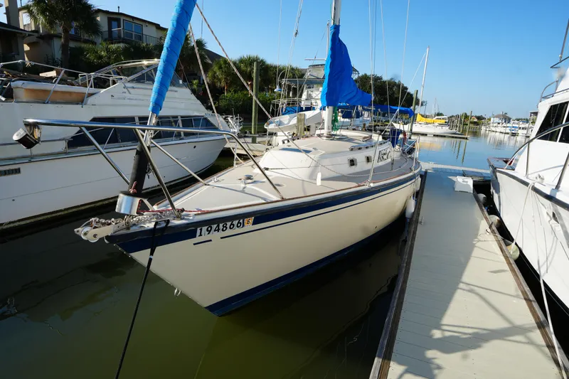 Slide: The Image of 1984 O'Day 30 sailboat docked in a marina, featuring blue sail covers. - 2