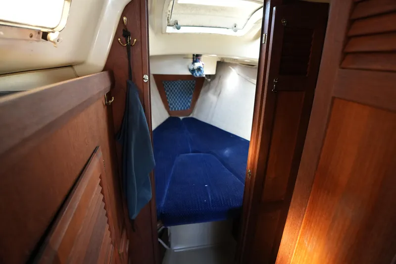 Slide: The Image of Cozy cabin interior of 1984 O'Day 30 sailboat with blue cushions and wooden finish. - 8