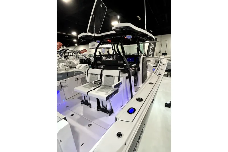 Slide: The Image of 2026 Blackfin 332 CC boat interior with seating and modern design at a showroom. - 10