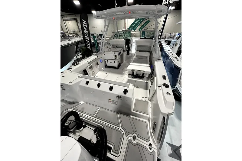 Slide: The Image of 2026 Blackfin 302 DC boat interior with seating and modern design at a showroom. - 13