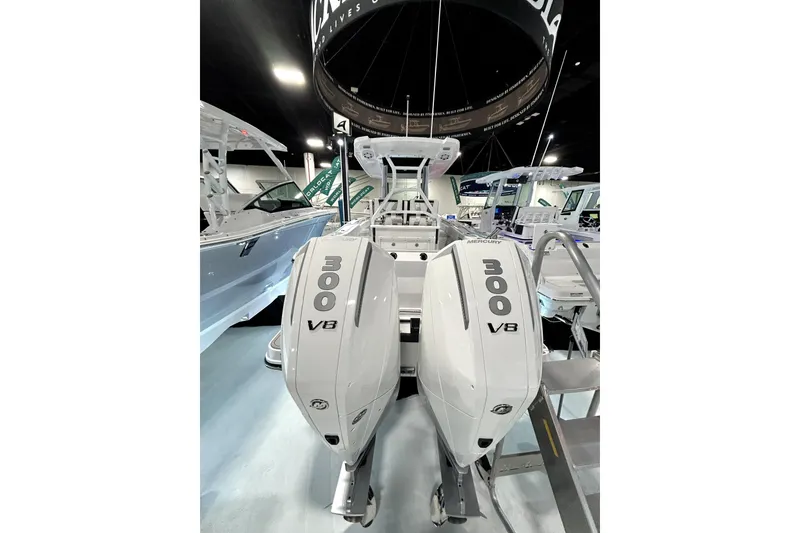Slide: The Image of 2026 Blackfin 272 CC boat with dual 300 V8 Mercury engines displayed indoors. - 14
