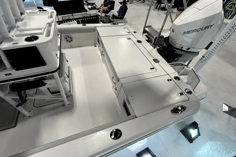 Slide: The Image of 2026 Blackfin 242 HB boat interior with Mercury engine, showcasing spacious deck and storage. - 11
