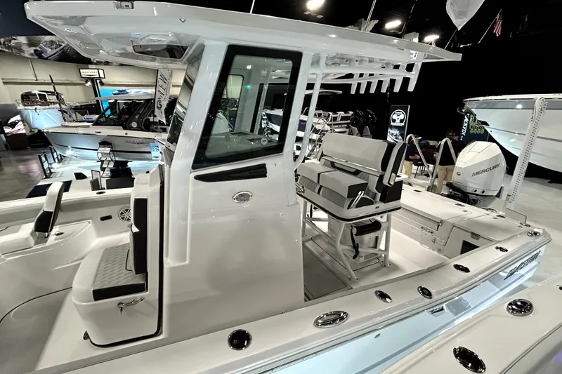 Slide: The Image of 2026 Blackfin 242 HB boat interior at a showroom, featuring seating and modern design. - 2