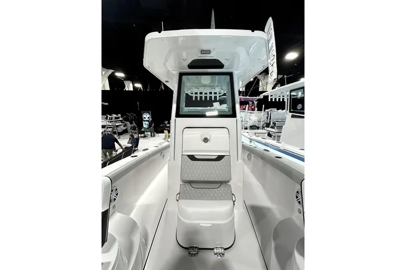 Slide: The Image of 2026 Blackfin 242 HB boat interior with seating and console, showcased at an indoor event. - 8