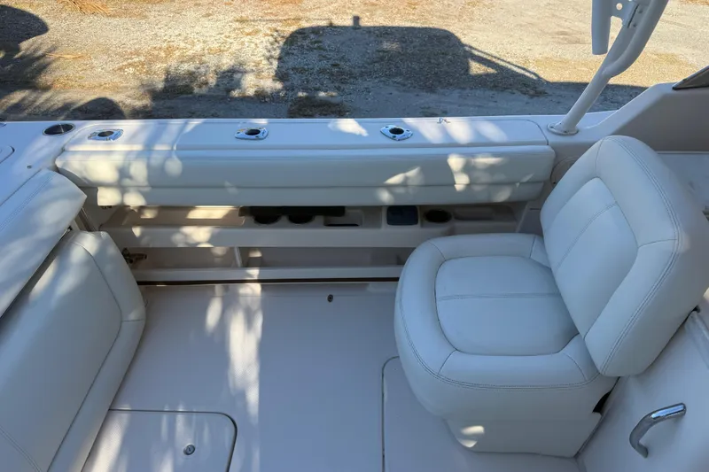 Slide: The Image of 2015 Grady-White Freedom 307 boat interior with white seating and rod holders. - 10