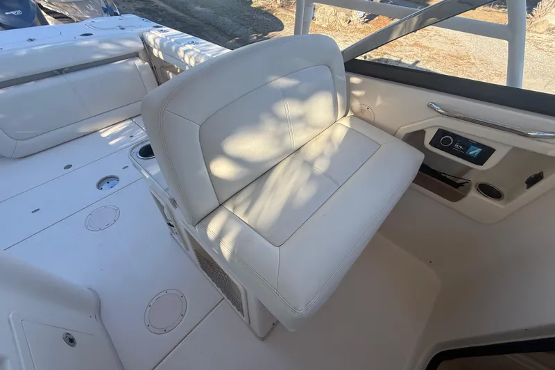 Slide: The Image of 2015 Grady-White Freedom 307 boat interior with white seating and control panel. - 15
