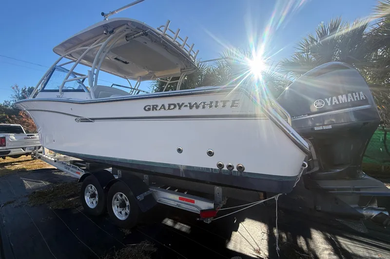 Slide: The Image of 2015 Grady-White Freedom 307 boat on trailer with Yamaha engines, sunlit background. - 2