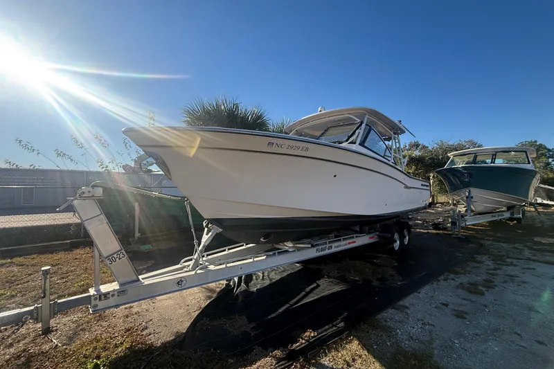 Slide: The Image of 2015 Grady-White Freedom 307 boat on trailer under bright sun. - 3