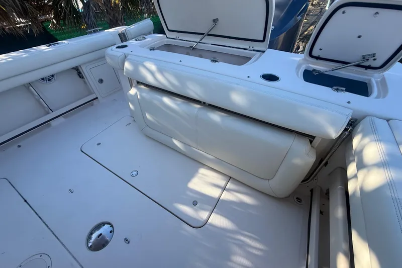 Slide: The Image of 2015 Grady-White Freedom 307 boat interior with white seating and storage compartments. - 33