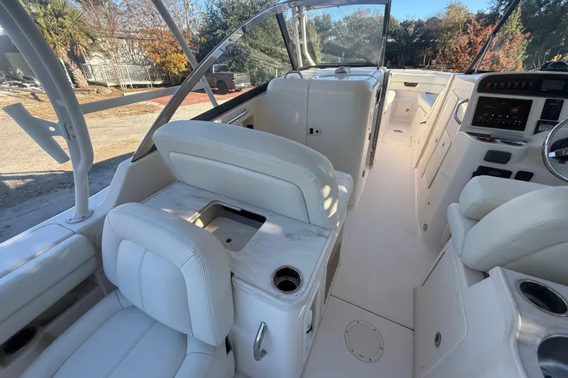 Slide: The Image of 2015 Grady-White Freedom 307 boat interior with white seating and control panel. - 36