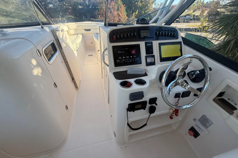 Slide: The Image of 2015 Grady-White Freedom 307 boat cockpit with steering wheel and control panel. - 38