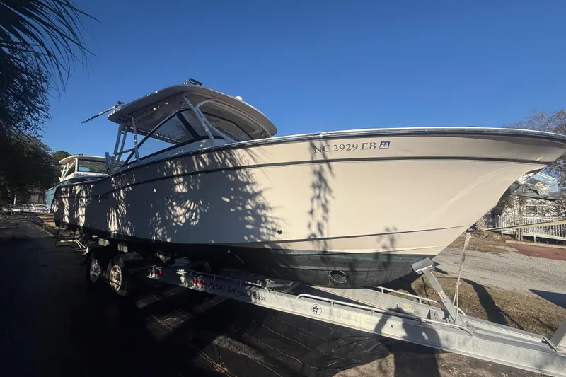 Slide: The Image of 2015 Grady-White Freedom 307 boat on trailer under clear blue sky. - 4