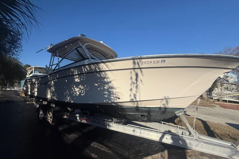 Slide: The Image of 2015 Grady-White Freedom 307 boat on trailer under clear blue sky. - 5