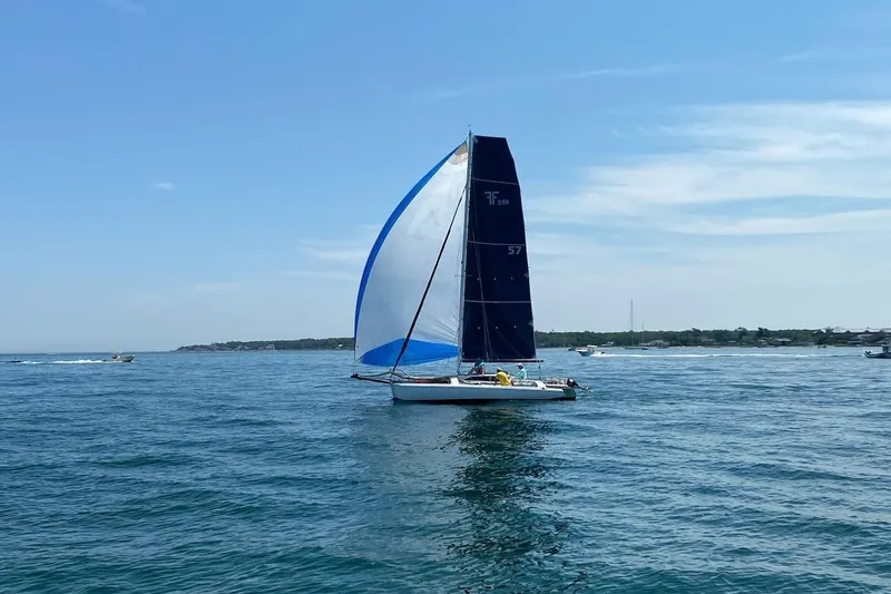 Slide: The Image of Sailboat Corsair F-28R #57 from 1998 on open water under clear skies. - 2
