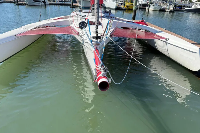 Slide: The Image of 1998 Corsair F-28R #57 trimaran docked in marina, featuring red netting and sleek design. - 9