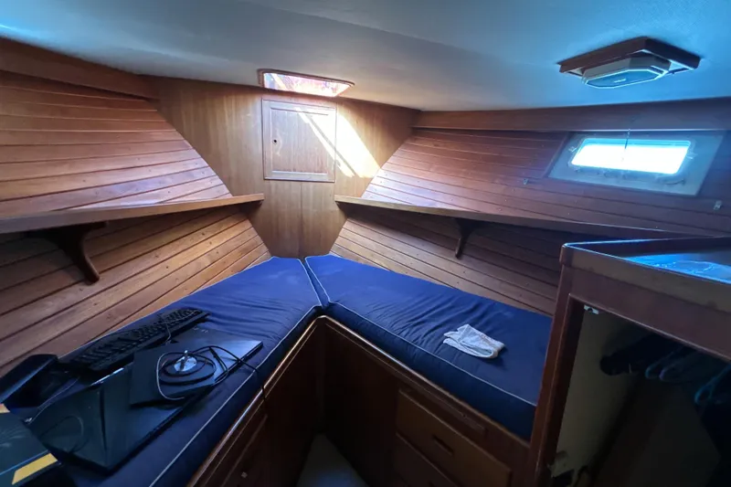 Slide: The Image of 1985 Kong & Halvorsen Island Gypsy cabin interior with wooden paneling and blue bedding. - 11