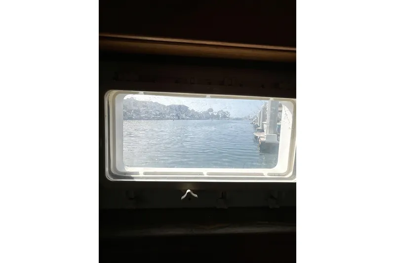 Slide: The Image of View through a window on a 1985 Kong & Halvorsen Island Gypsy boat, overlooking calm waters. - 25