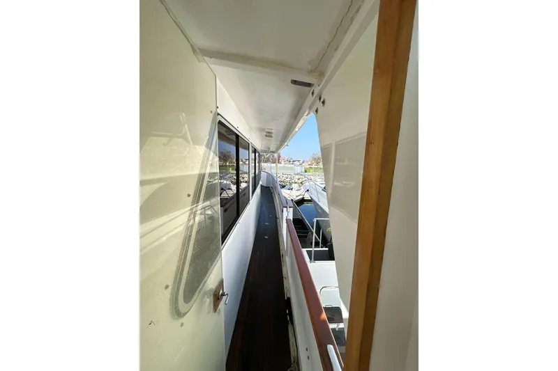 Slide: The Image of Narrow walkway on 1985 Kong & Halvorsen Island Gypsy yacht, featuring windows and wooden railings. - 32
