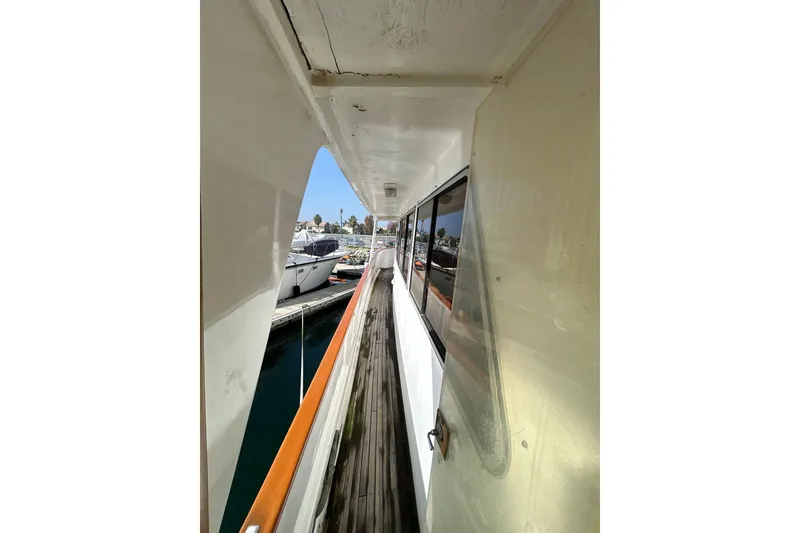 Slide: The Image of 1985 Kong & Halvorsen Island Gypsy yacht deck view, showcasing wooden walkway and marina. - 33