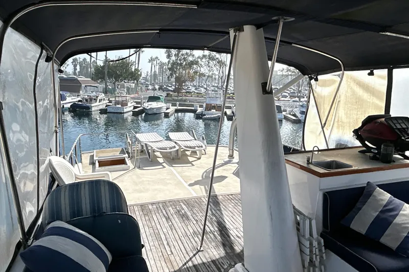 Slide: The Image of 1985 Kong & Halvorsen Island Gypsy yacht interior with marina view, featuring lounge chairs and seating area. - 39