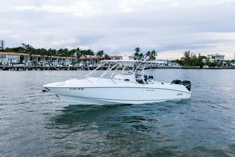 Slide: The Image of 2005 Boston Whaler 320 Outrage Cuddy Cabin on calm waters near a marina. - 12